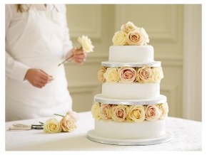 Traditional tiered wedding cake with rose petals between each layer