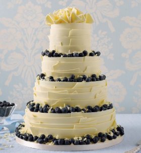 four tier chocolate cake is smothered in chocolate ganache