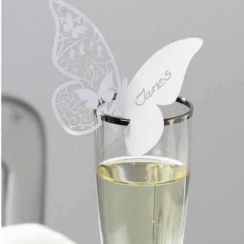 Butterfly shaped table place card perched on a wine glass rim