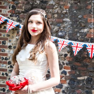 Bride with bright red bouquet and Union Jack bunting